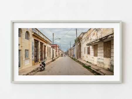 Woman cycling down the street in Cuba | Wall Art Supply