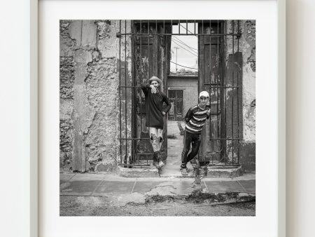 Young and friendly Cuban boys standing at a gated entrance | Wall Art Sale